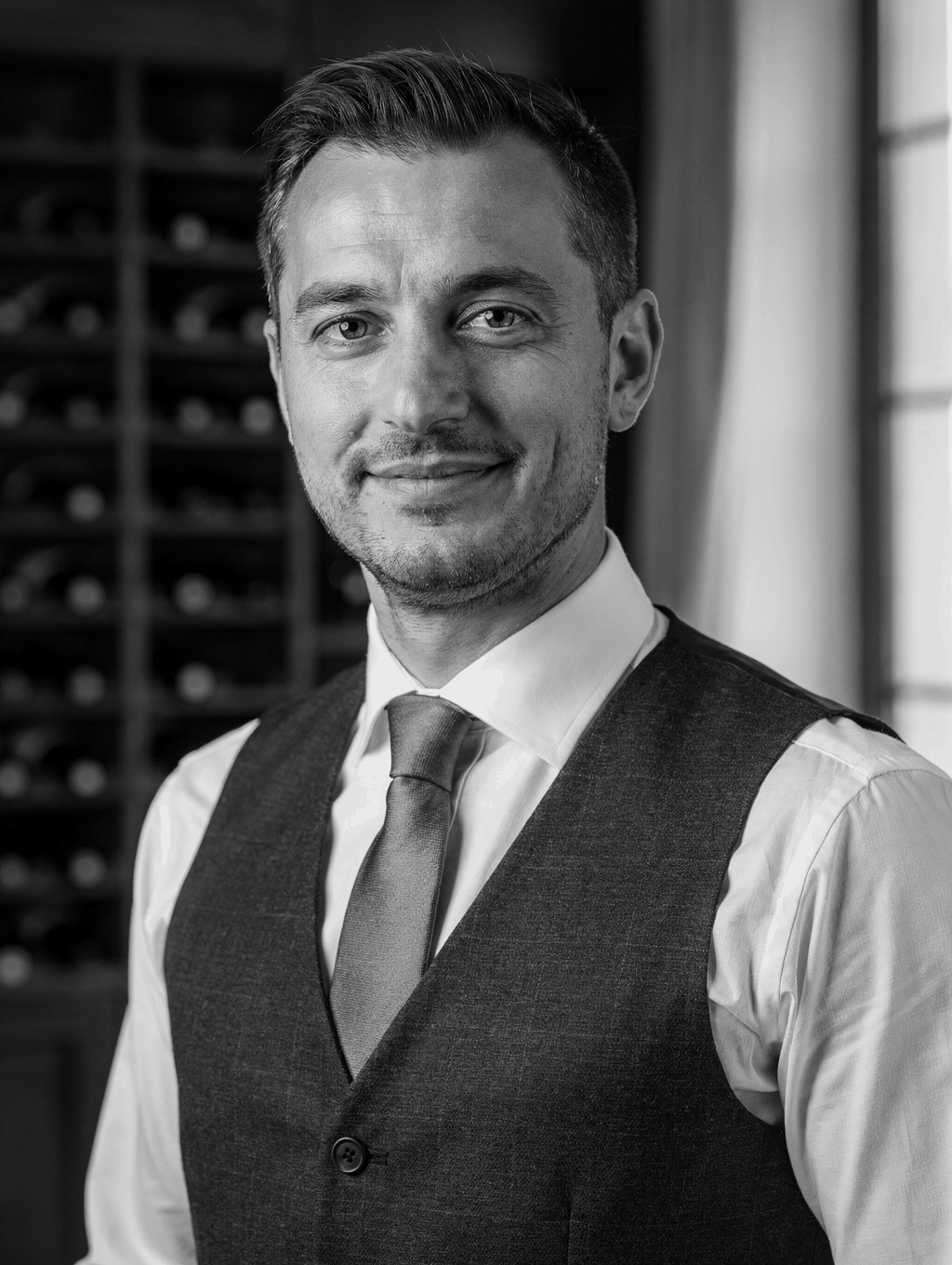 Sommelier Luca Moretti selecting a vintage wine in the cellar